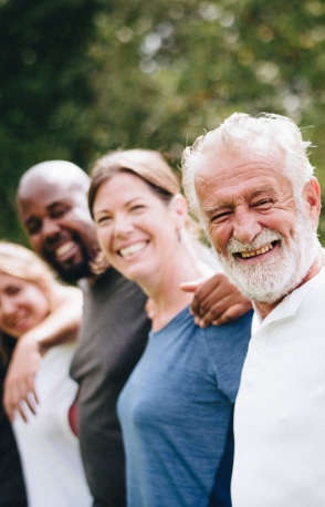 groupe de personnes qui se tiennent par les epaules et sourient