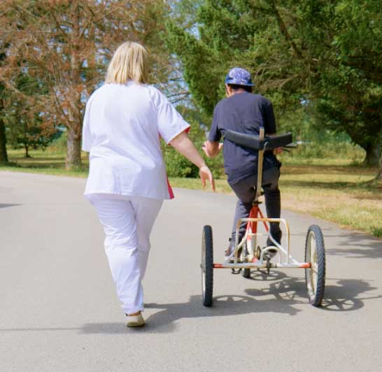 personne en situation de handicap qui fait du vélo adapté accompagné format carre