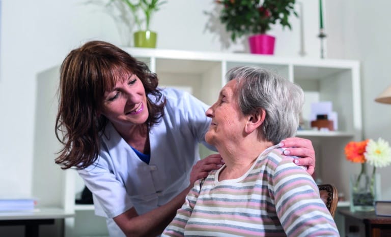 nurse,with,her,hands,on,the,shoulder,of,a,senior